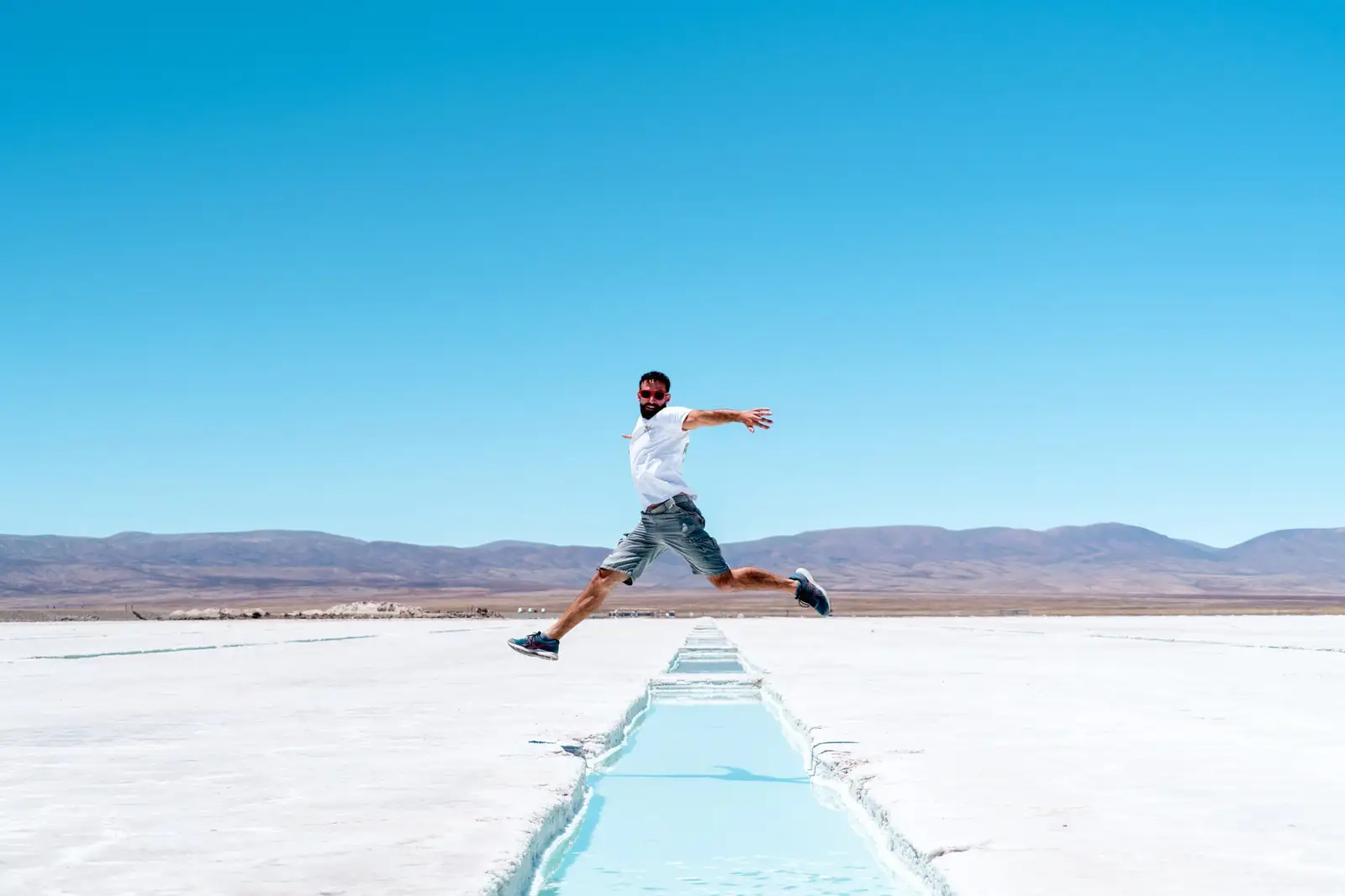 A visitor jumping on the salt flats