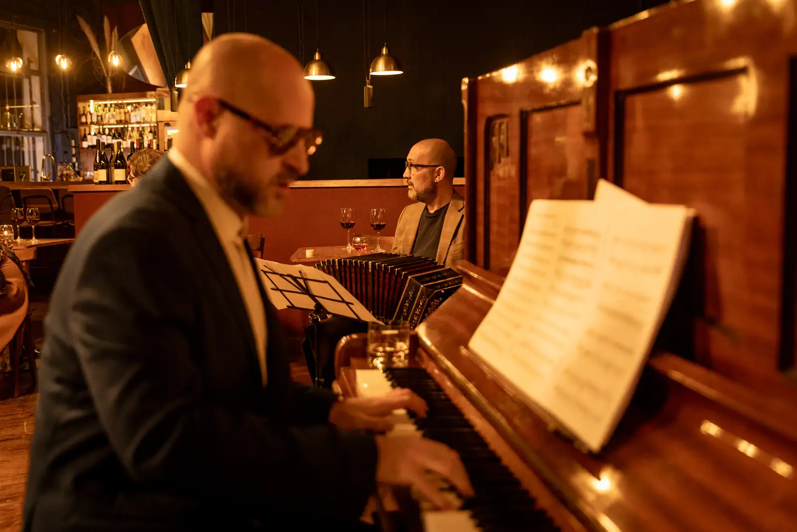 A bandoneón player reading from sheet music in a bar