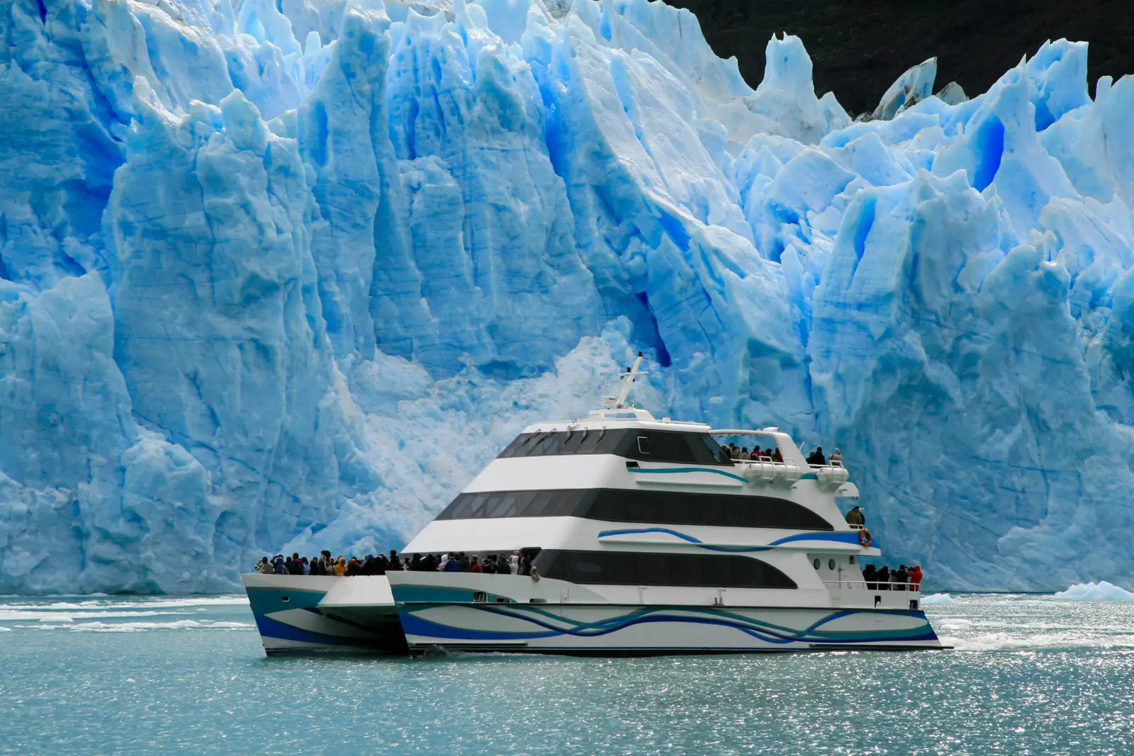 The ice wall of the Perito Moreno glacier, with a catamaran in front