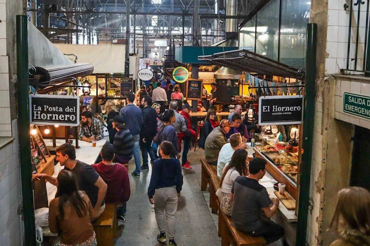 Inside the San Telmo market, stalls and people at the counters